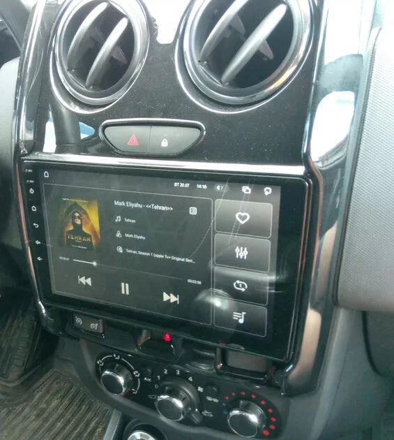 Autoradio 9 pouces avec son cadre noir installé dans la console d'un Dacia Duster phase 2 (fin 2013 à 2017), aérateurs ronds et climatisation d'origine conservés