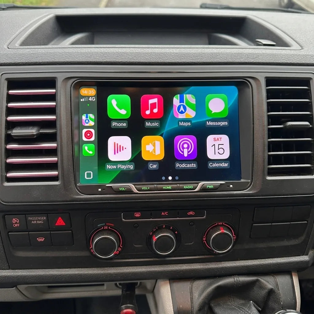 Autoradio CarPlay 9 pouces installé entre les aérateurs d'un Volkswagen Transporter, au-dessus des commandes de climatisation