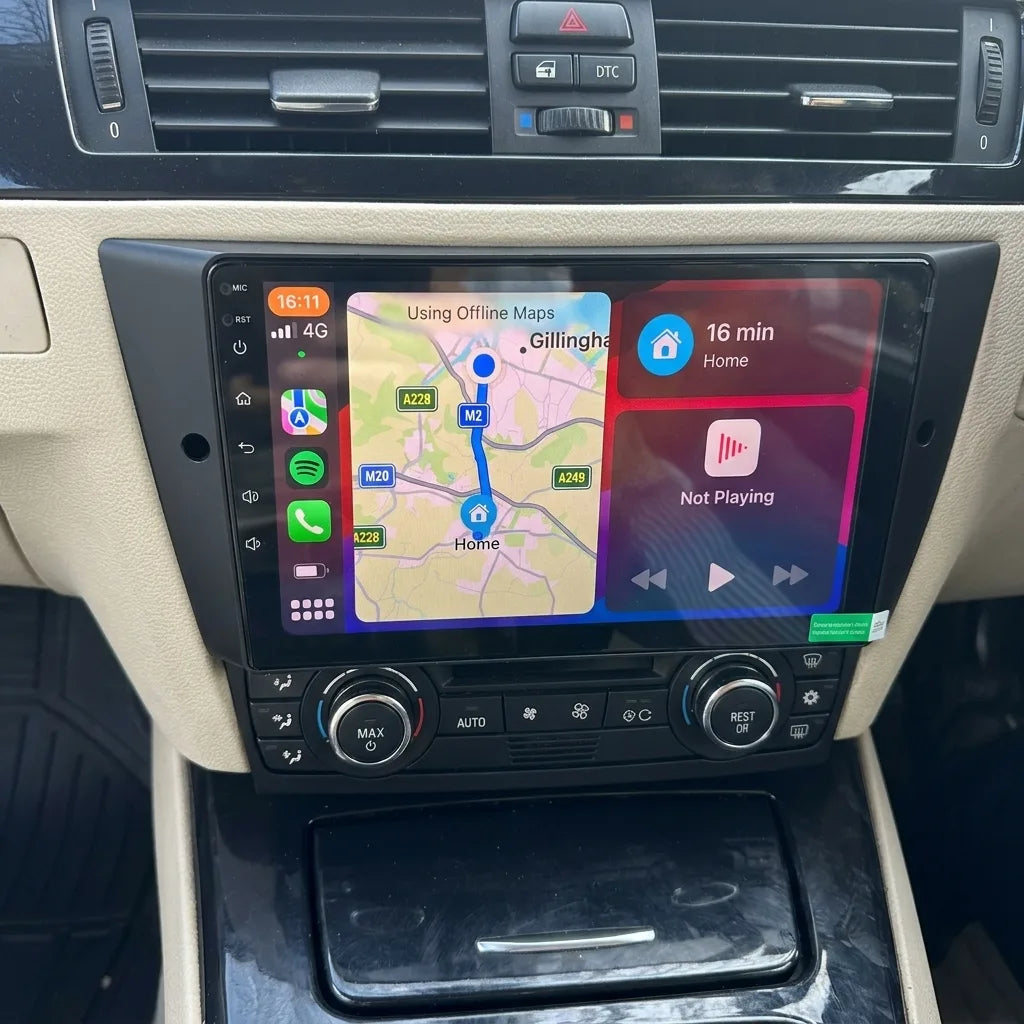 Autoradio CarPlay 9 pouces installé dans la console d'une BMW Série 3 E90, panneau de clim d'origine conservé