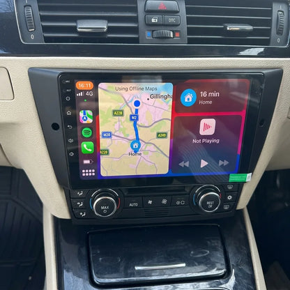 Autoradio CarPlay 9 pouces installé dans la console d'une BMW Série 3 E90, panneau de clim d'origine conservé