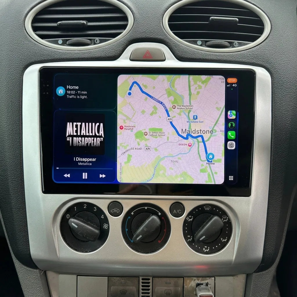 Autoradio CarPlay 9 pouces installé dans la console d'une Ford Focus 2 phase 2 (2008-2011), aérateurs ronds et climatisation d'origine conservés