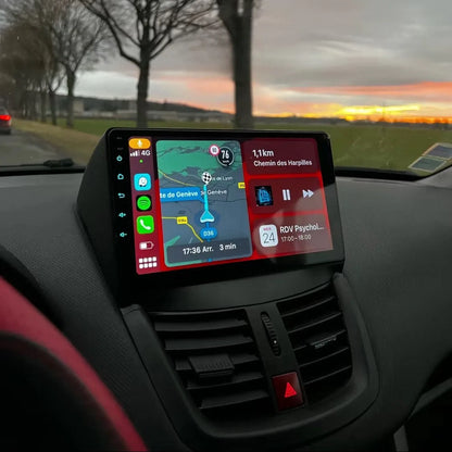 Autoradio CarPlay 9 pouces installé dans le tableau de bord d'une Peugeot 207, au-dessus des aérateurs