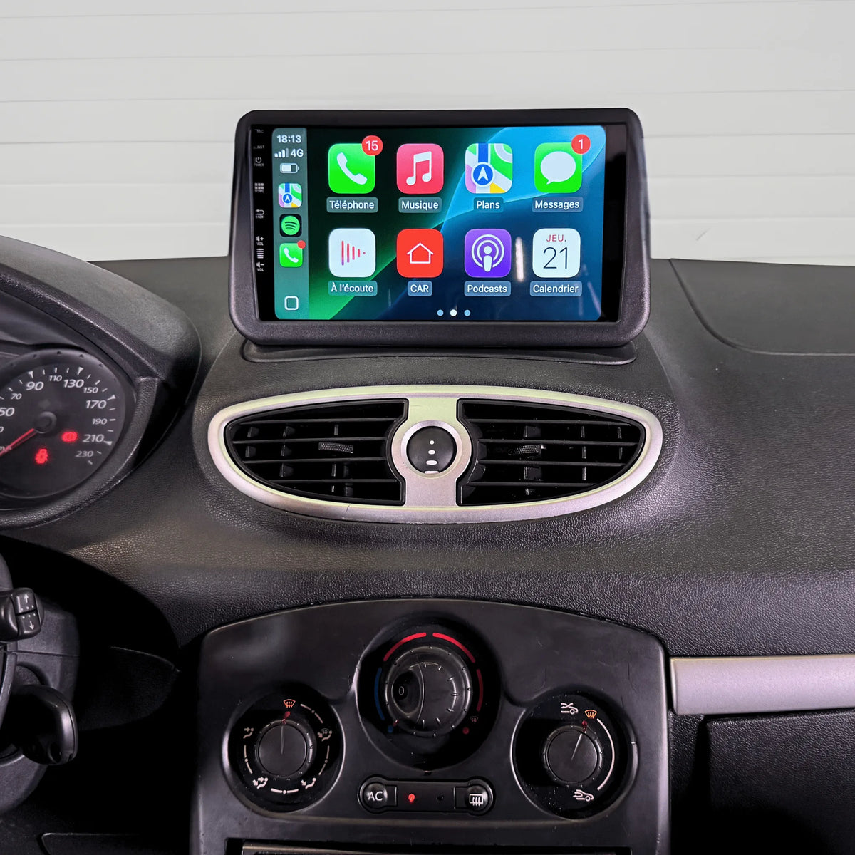 Autoradio CarPlay 9 pouces installé en haut du tableau de bord d'une Renault Clio 3 2005-2014, à la place de l'afficheur d'origine, au-dessus des aérateurs