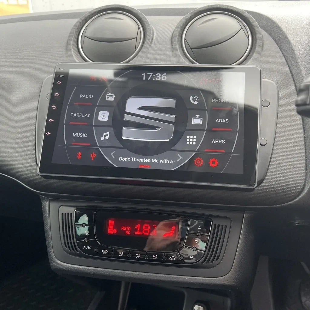 Autoradio écran tactile 9 pouces installé dans la console d'une Seat Ibiza 6J (2008-2015), sous les aérateurs ronds, climatisation d'origine conservée