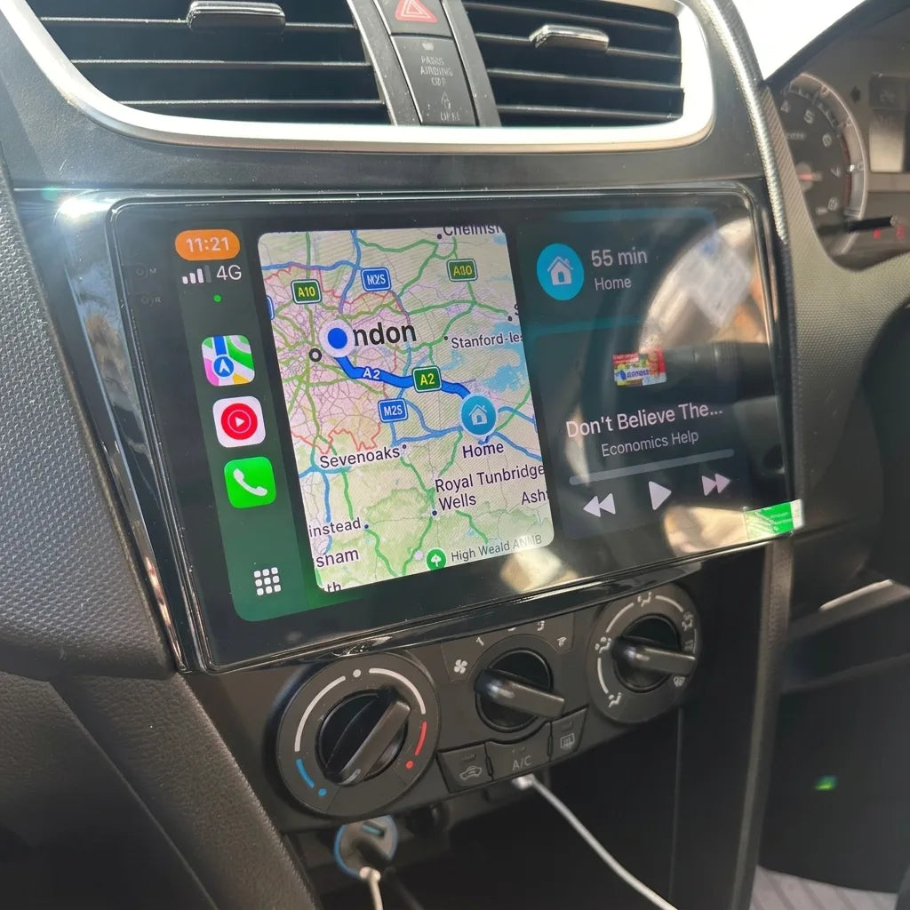 Autoradio CarPlay 9 pouces installé dans la console d'une Suzuki Swift 3 (2010-2017), navigation Apple Plans affichée, climatisation d'origine conservée