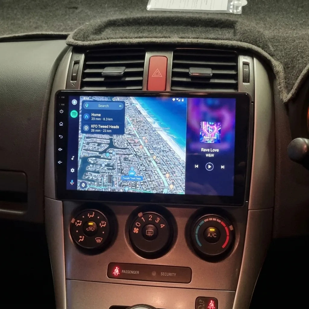 Autoradio écran tactile 9 pouces installé dans la console argentée d'une Toyota Auris (2007-2012), commandes de climatisation d'origine conservées